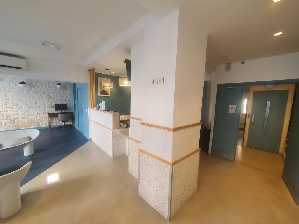 Un intérieur moderne avec un comptoir d’accueil, un mur en pierre et une baignoire.