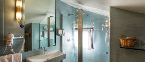 A modern bathroom with a large mirror, a sink, a shower enclosure, and a towel rack.