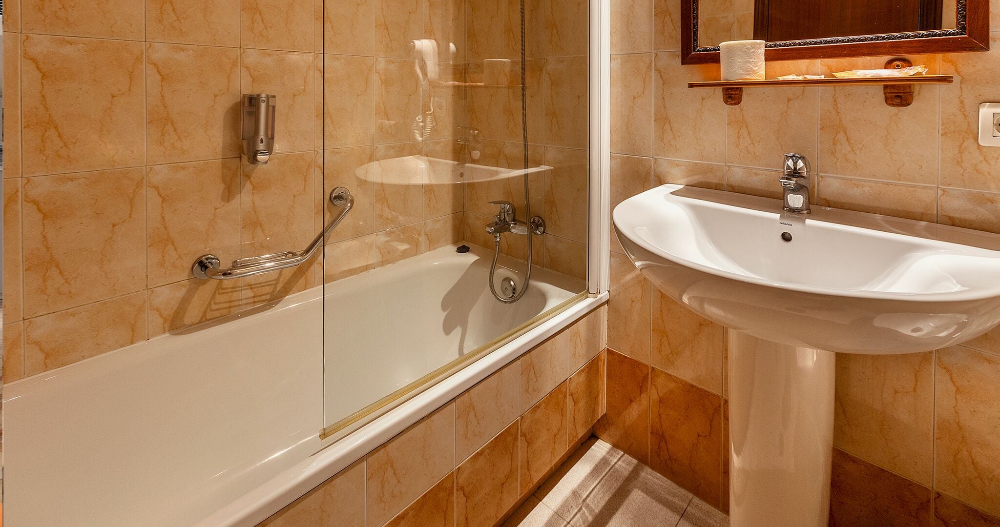 Une salle de bain équipée d’une baignoire, d’un lavabo et d’une douche à parois en verre.
