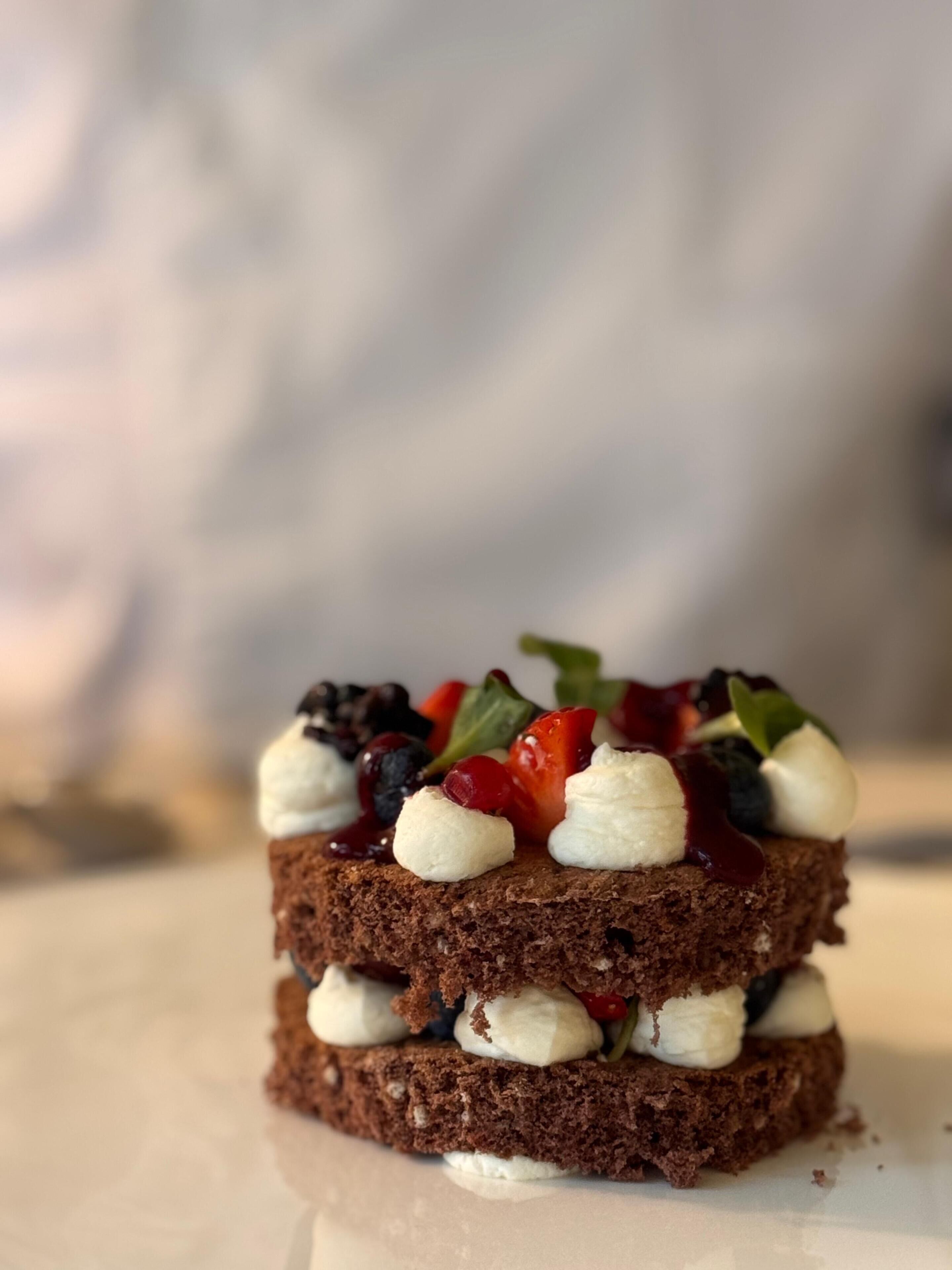 A layered dessert with whipped cream and berries on top.