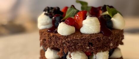 A layered dessert with whipped cream and berries on top.