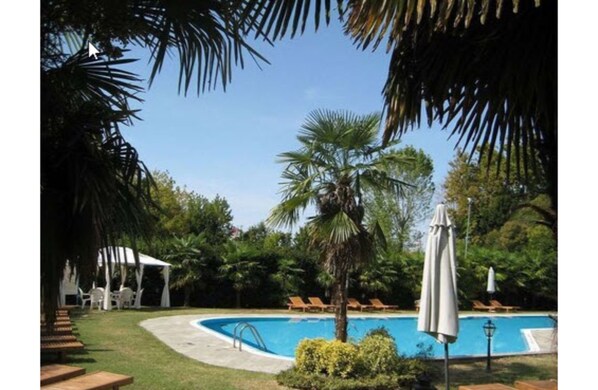 Piscine extérieure, parasols de plage, chaises longues