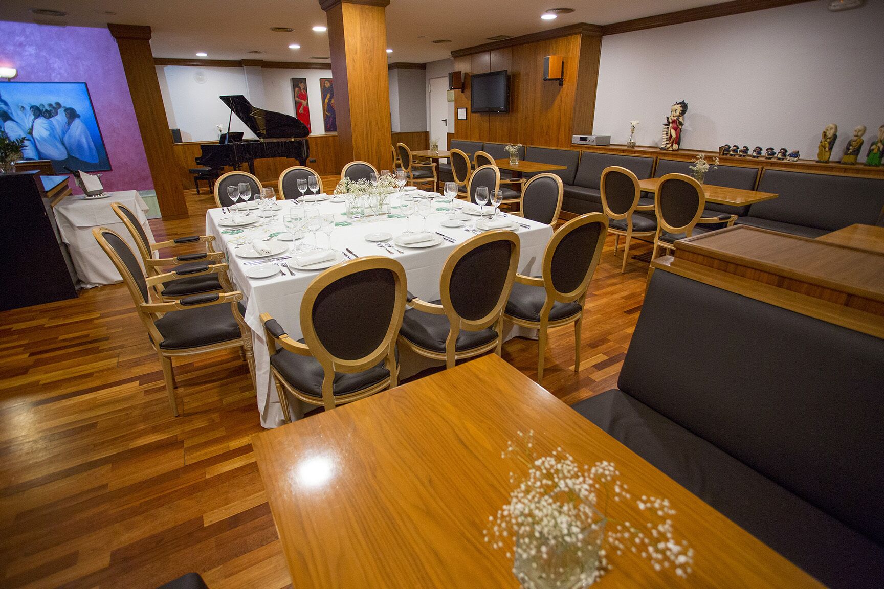 A dining area with a long table set for a meal, surrounded by chairs.