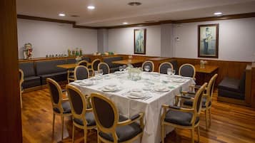 A dining area with a round table set for six, surrounded by wooden chairs with cushioned seats.