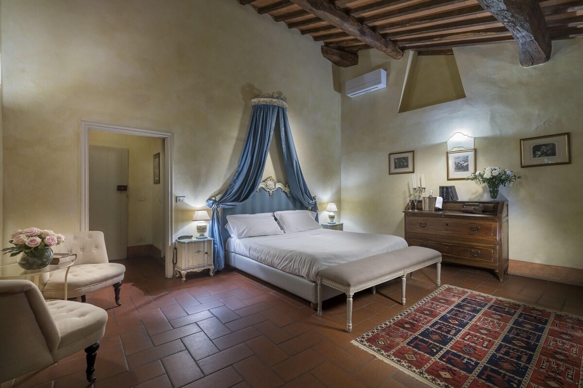 Un dormitorio con cama, mesita de noche, cómoda, silla y alfombra.