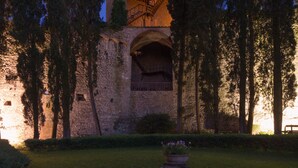 Un edificio histórico con fachada de piedra, entrada de arco y un balcón de madera.