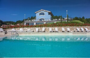 Piscine extérieure en saison, parasols, chaises longues