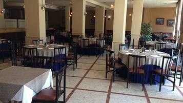 Un restaurant spacieux, doté de nombreuses tables et chaises disposées selon un plan en forme de grille.