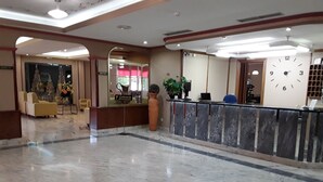A spacious lobby with a marble floor, a reception desk, a clock, and a cafe area. - Hotel Castro (Santiago de Compostela)
