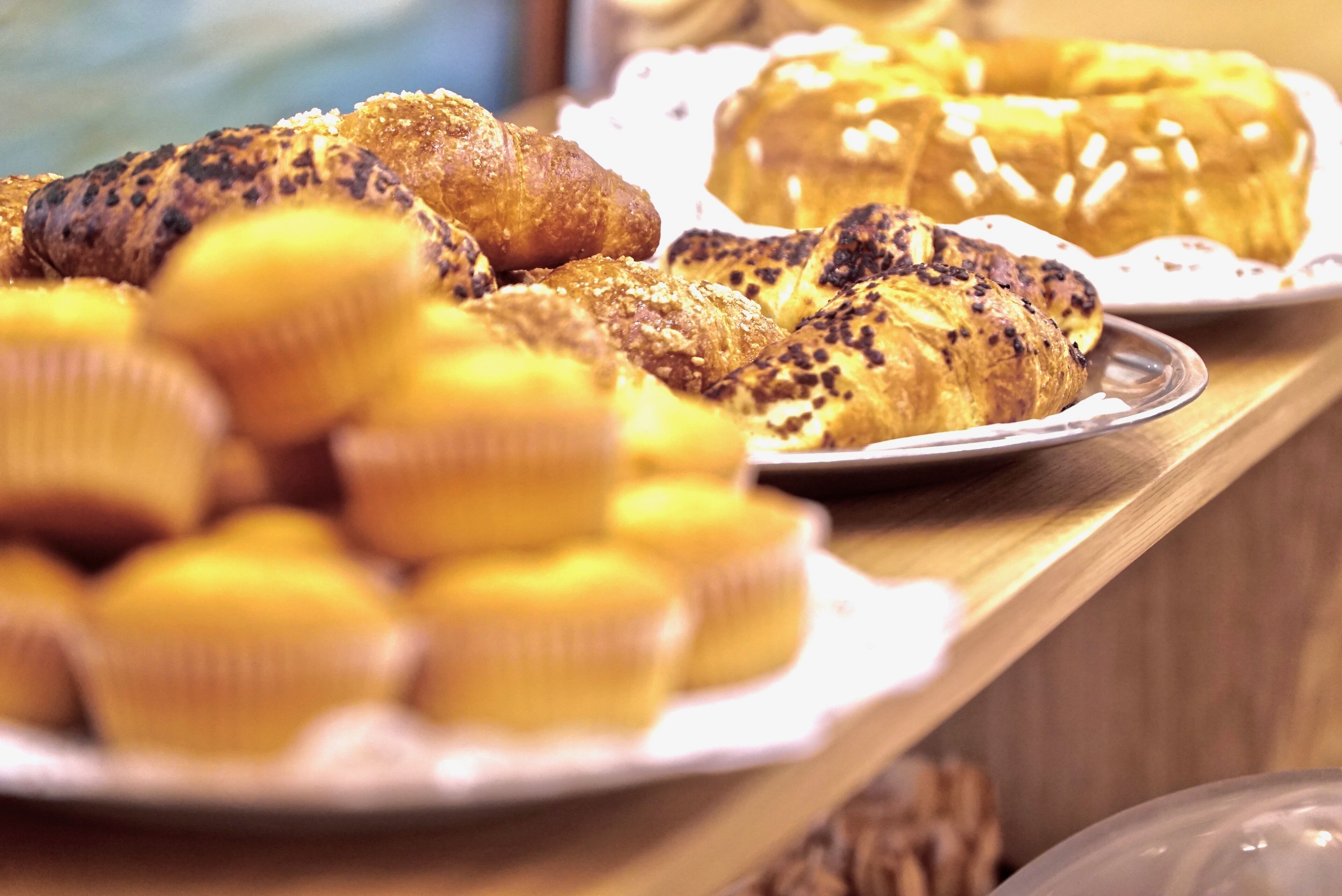 Una selezione di prodotti da forno esposta, tra cui muffin e pasticcini.