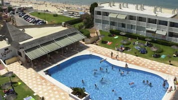 Hotel amb una gran piscina, zones d'estar a l'aire lliure i vistes a la platja.