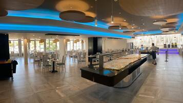 Rebedor modern d'hotel amb zona de buffet central, espais d'seure i taulell de recepció.