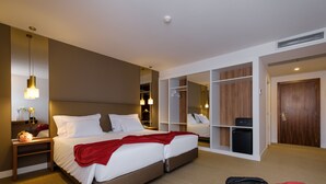 A hotel room with a large bed, bedside tables, a wardrobe, and a mirror. - Hotel Regina (Ourem)