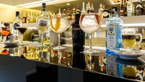 A bar area with various bottles and glasses of alcohol, including Martini and Bombay Sapphire Gin. - Hotel Regina (Ourem)