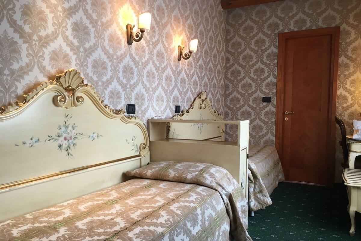 Een kamer met een bed, een kast, een spiegel en een deur.