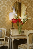 Un'elegante toeletta in stile vintage con uno specchio, una lampada e un vaso con fiori.