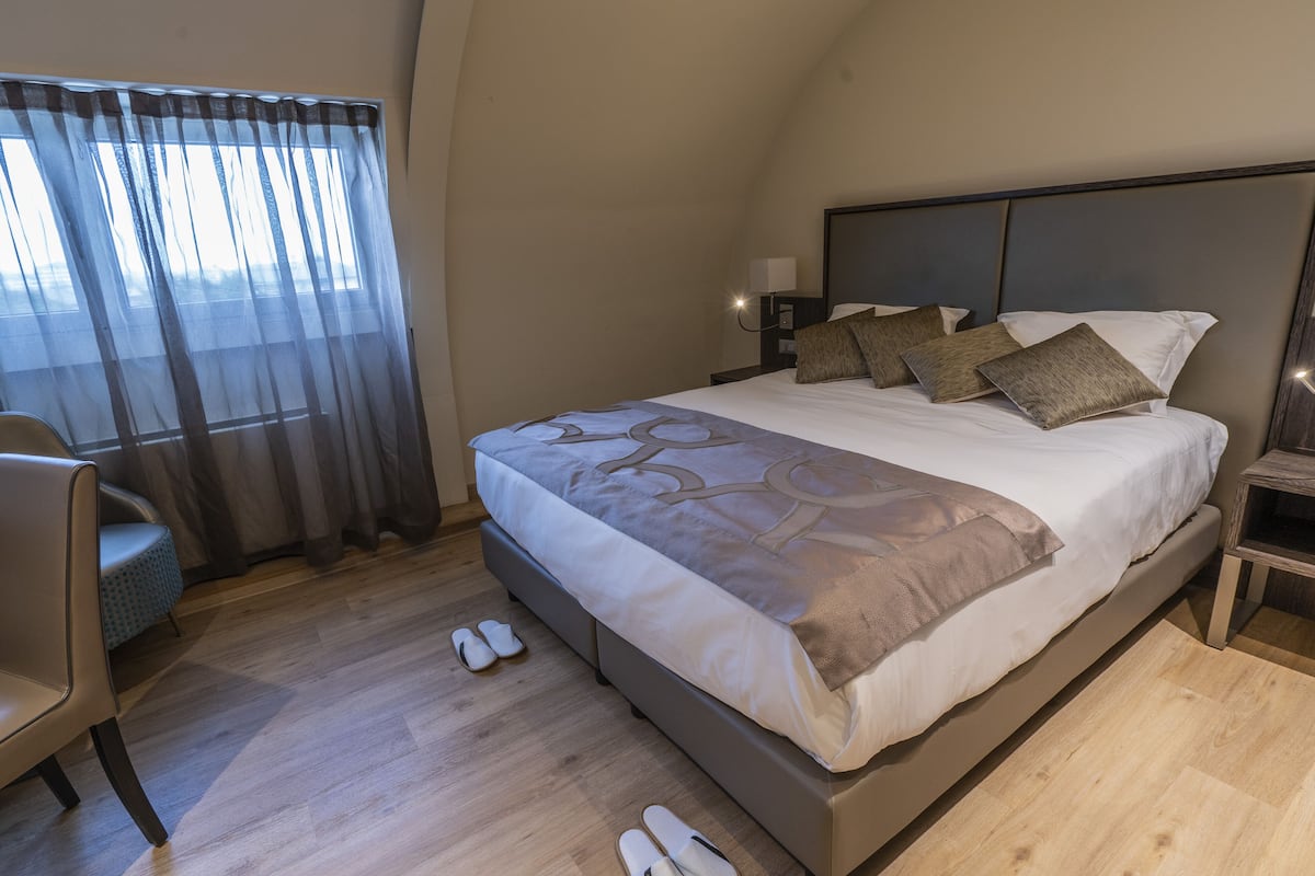 Une chambre d’hôtel moderne avec un grand lit, un bureau et une chaise.