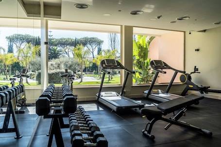 A gym with treadmills, dumbbells, and a bench.. Hotel Isola Sacra Rome Airport