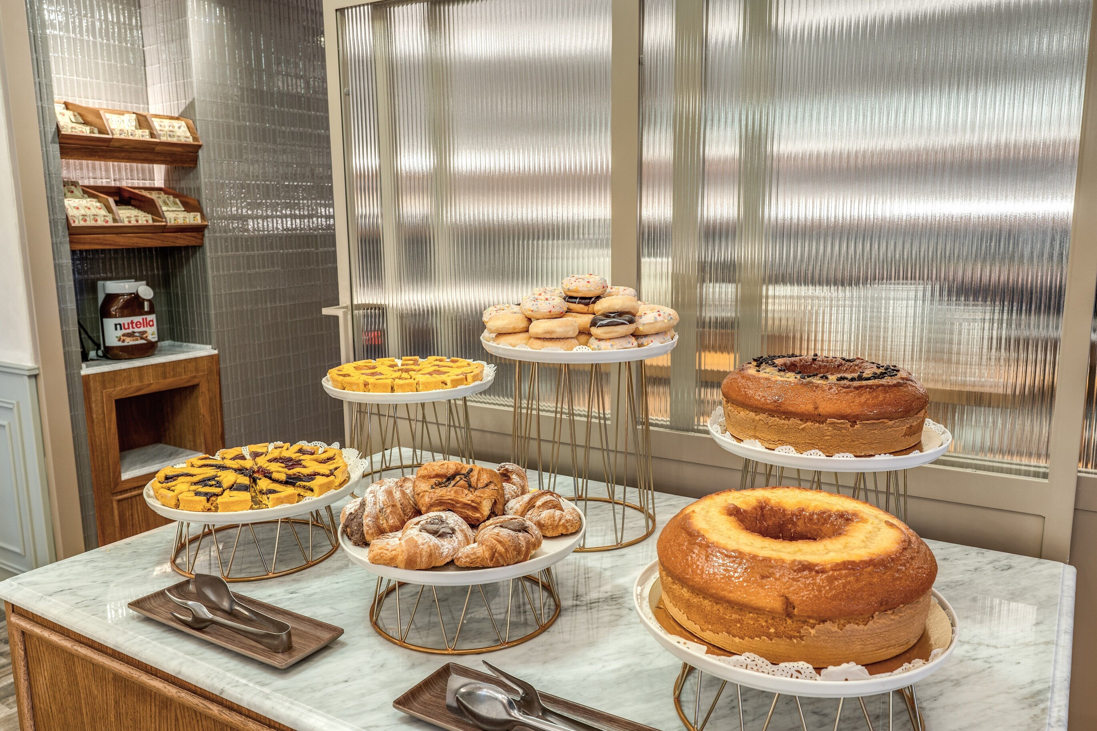 A buffet table with various pastries and cakes.