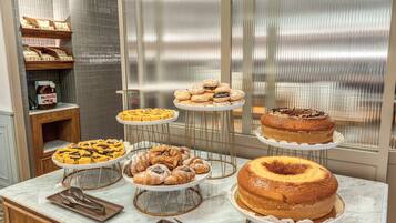 A buffet table with various pastries and cakes.