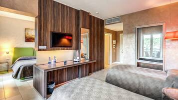 Ein modernes Hotelzimmer mit einer Wandpaneele aus Holz, einem Flachbildfernseher, einem Schreibtisch mit Spiegel und einem großen Fenster.