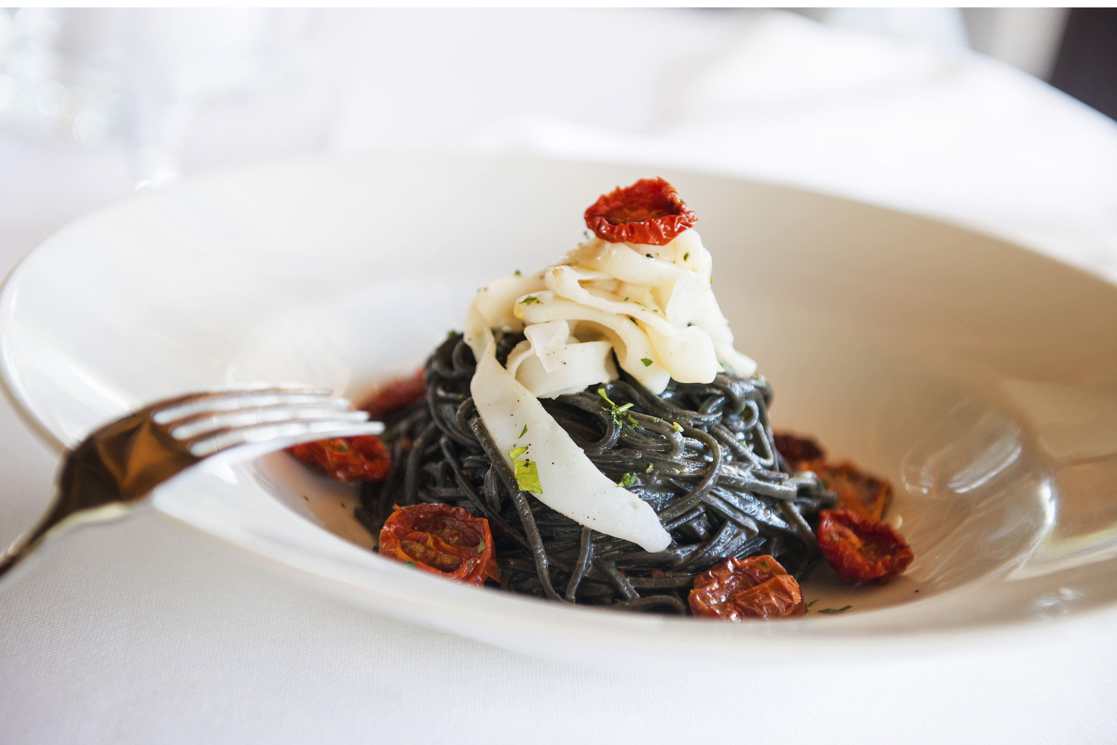 A plate of pasta with a fork on the side.
