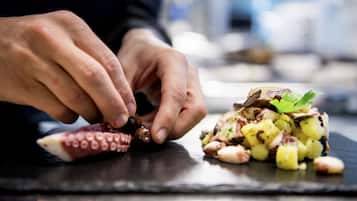 A person preparing food on a slate board, with a focus on hands and food items.