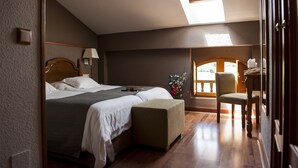 Een slaapkamer met een bed, nachtkastje, lamp en uitzicht op de omgeving.
