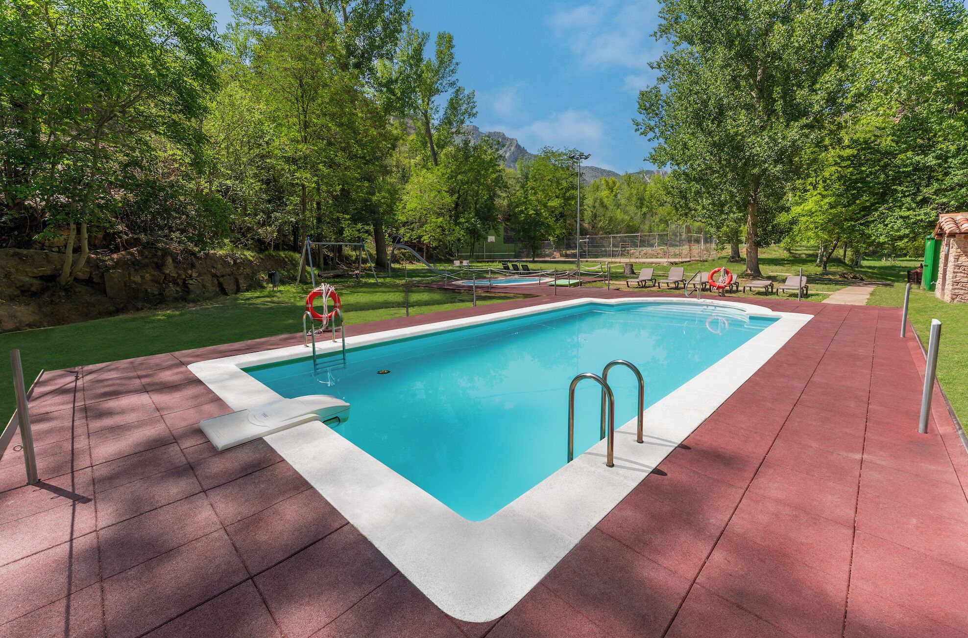 Una piscina al aire libre de temporada, sombrillas, tumbonas