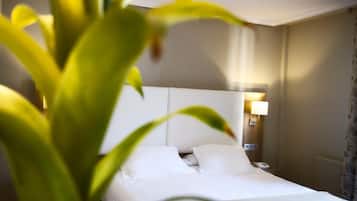 A hotel room with a bed, a bedside lamp, and a telephone.