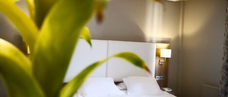 Una habitación de hotel con una cama, una lámpara de noche y un teléfono.