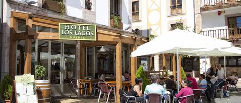 A hotel named 'Hotel Los Lagos Nature' with outdoor seating and potted plants.