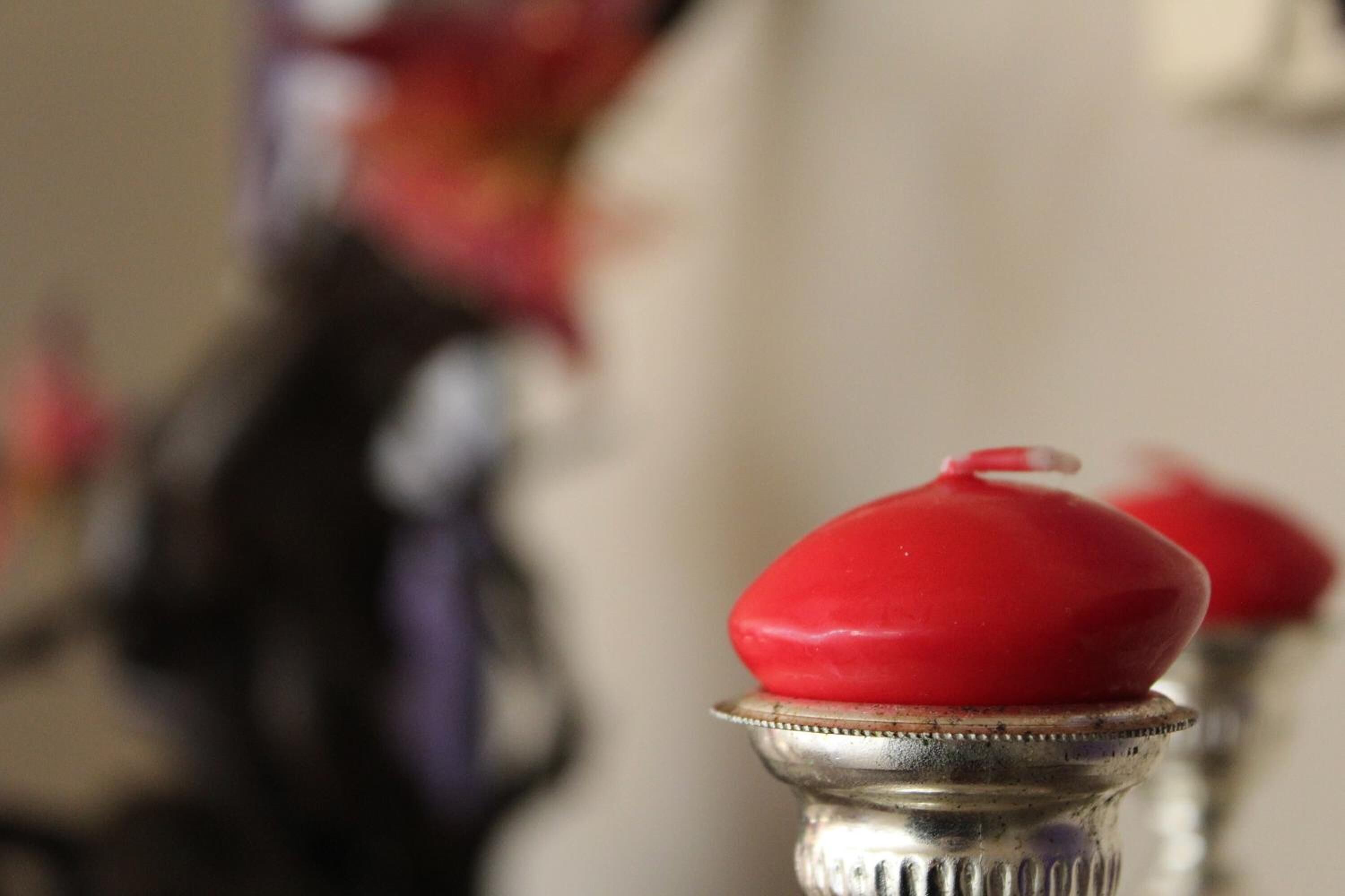 A close-up of a silver object with a red lid, possibly a part of a piece of furniture or equipment.