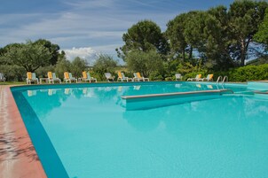 Una piscina al aire libre de temporada, sombrillas