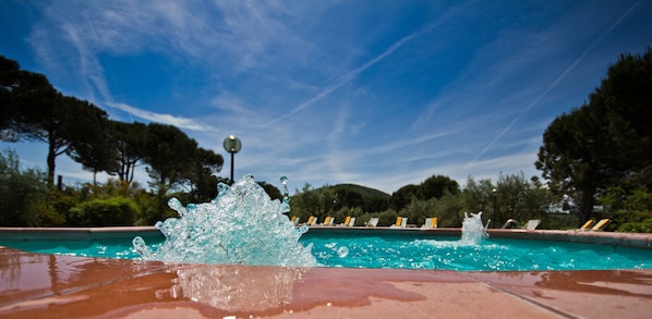 Seasonal outdoor pool, open 10:00 AM to 7:00 PM, pool umbrellas