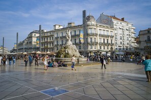 A public square with a central fountain, surrounded by historic buildings and a crowd of people. - Hotel Royal (Montpellier)