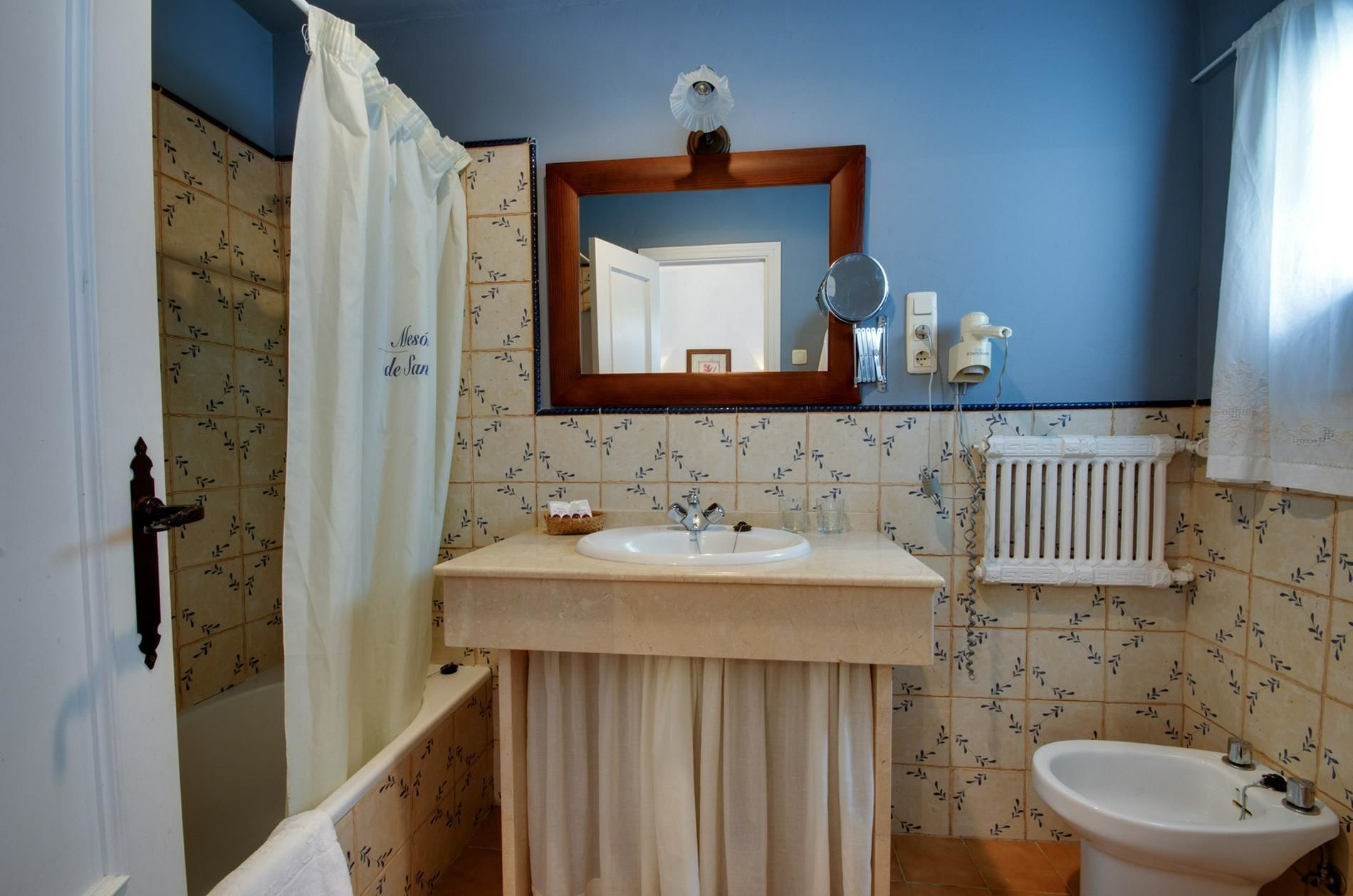 Baño con lavamanos, espejo e inodoro.