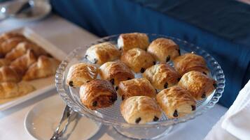 A glass serving tray with pastries on a table.
