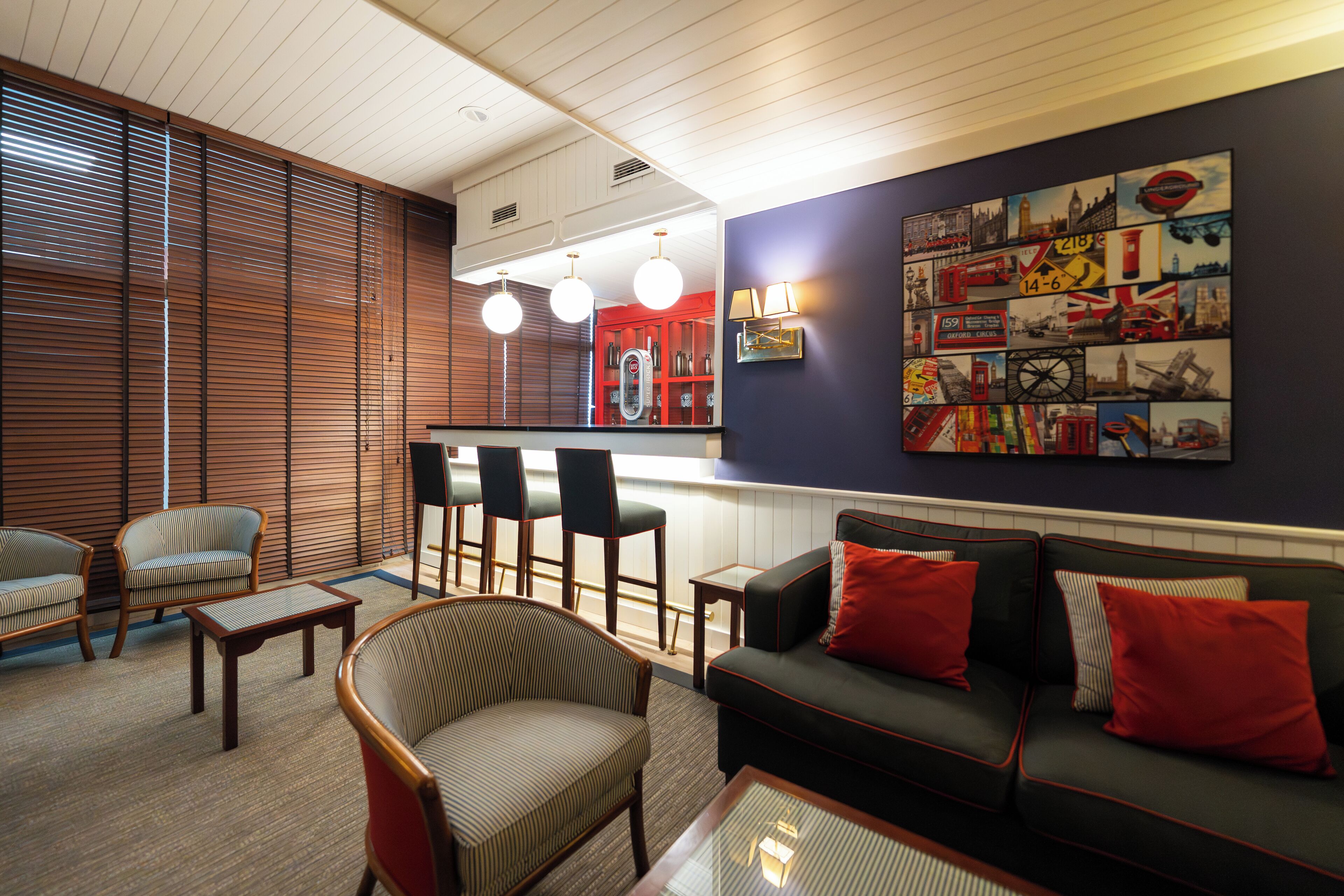 Een moderne woonkamer met een bank, stoelen, een salontafel en een bar met barkrukken.