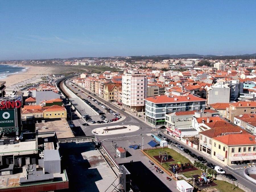 A coastal cityscape with a prominent casino sign, a roundabout, and a mix of residential and commercial buildings.