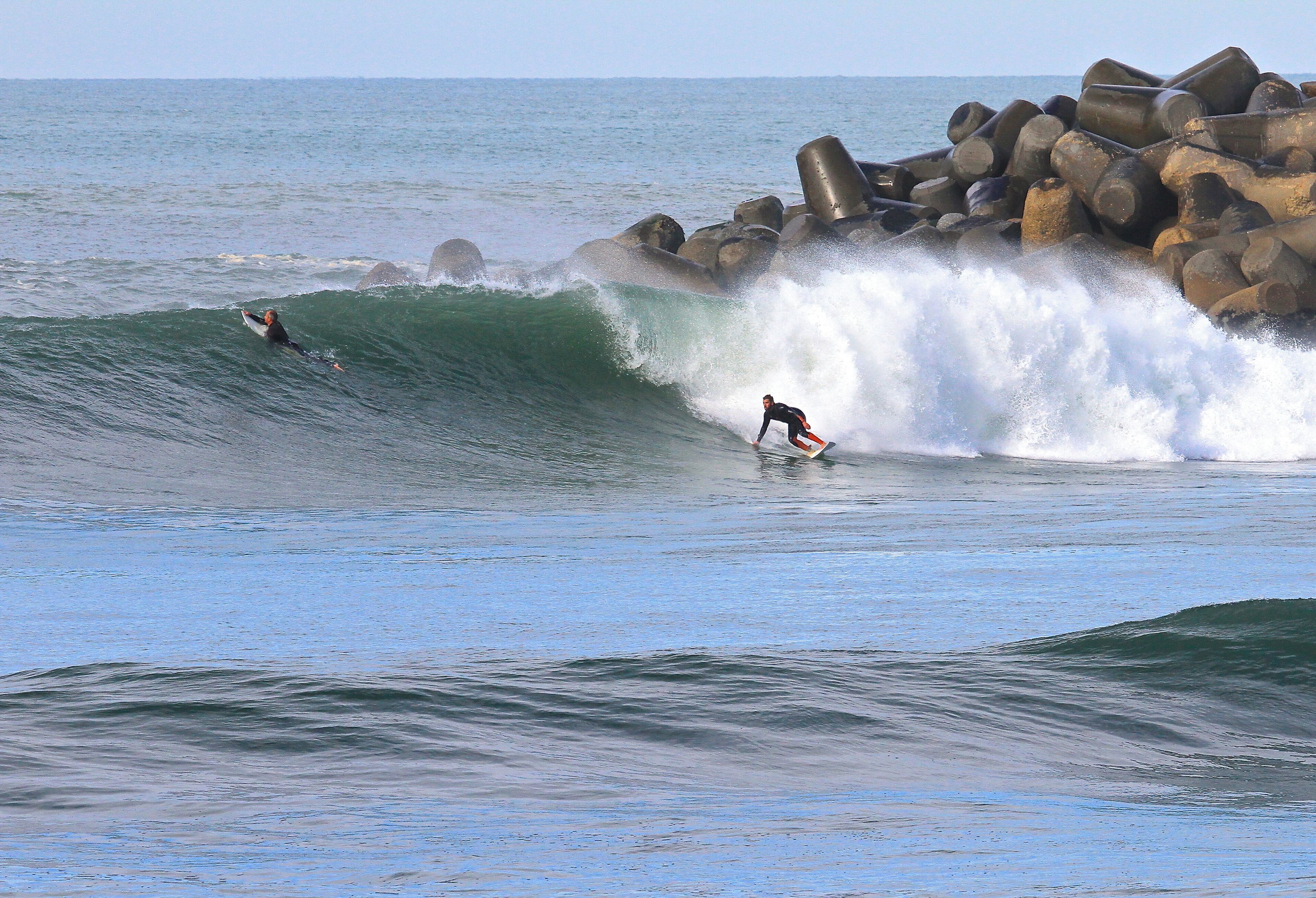 Une plage avec des vagues et des rochers.