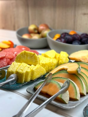A fruit platter with various fruits like pineapple, melon, and grapes.