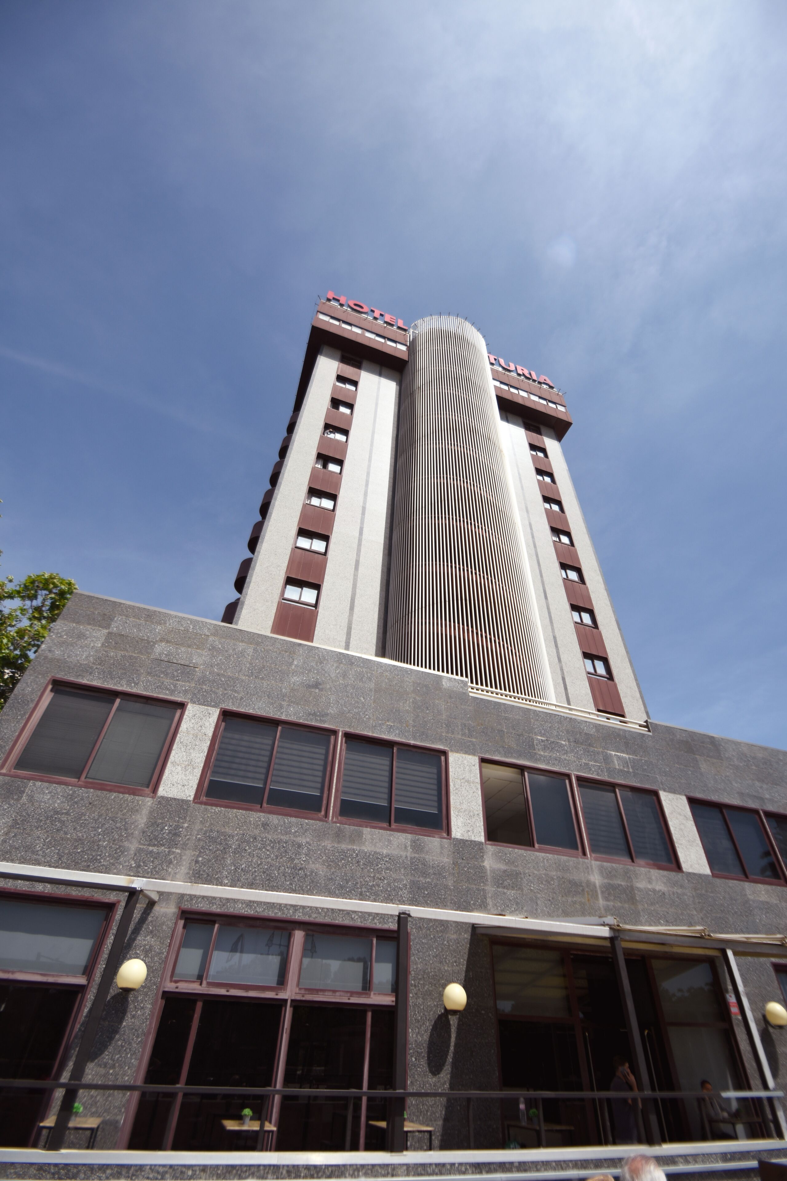 A tall hotel with a modern design, featuring a prominent vertical structure and multiple windows.