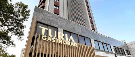A modern building with a sign for 'TURIA GASTROBAR'.