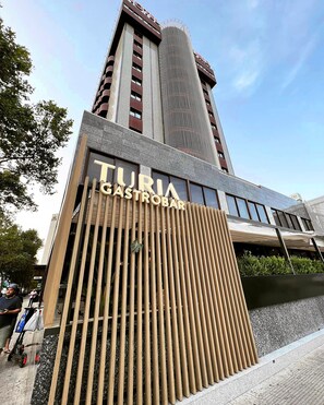 A modern building with a sign for 'TURIA GASTROBAR'.