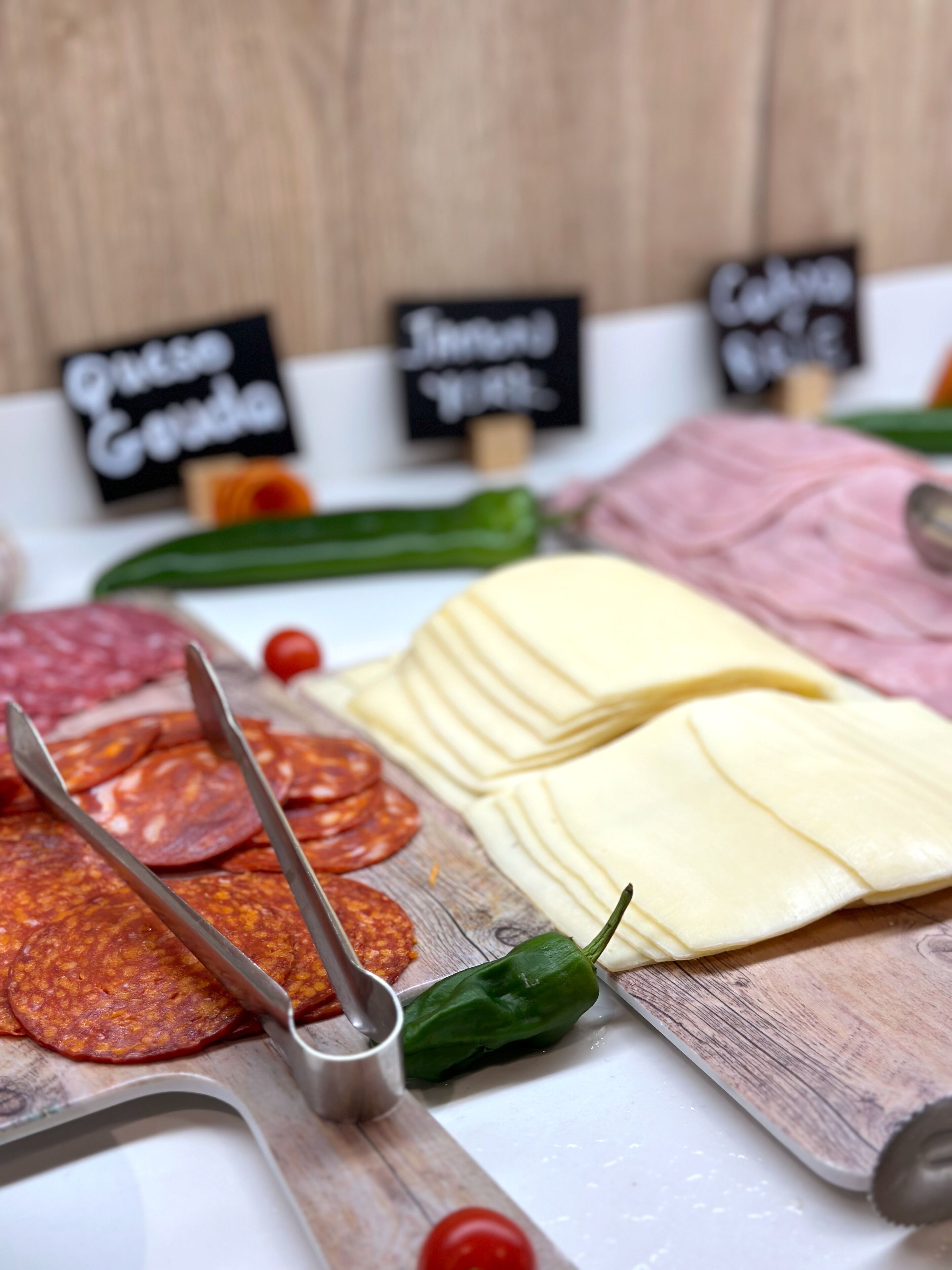Une sélection de charcuteries et de fromages, présentés sur une planche en bois.