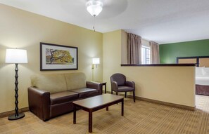 A hotel room with a sofa, armchair, coffee table, and a painting on the wall. - Extended Stay America Suites San Jose Edenvale North (San Jose)