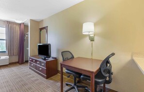 A hotel room with a wooden desk, a television, a chair, a lamp, and a window with curtains. - Extended Stay America Suites San Jose Edenvale North (San Jose)