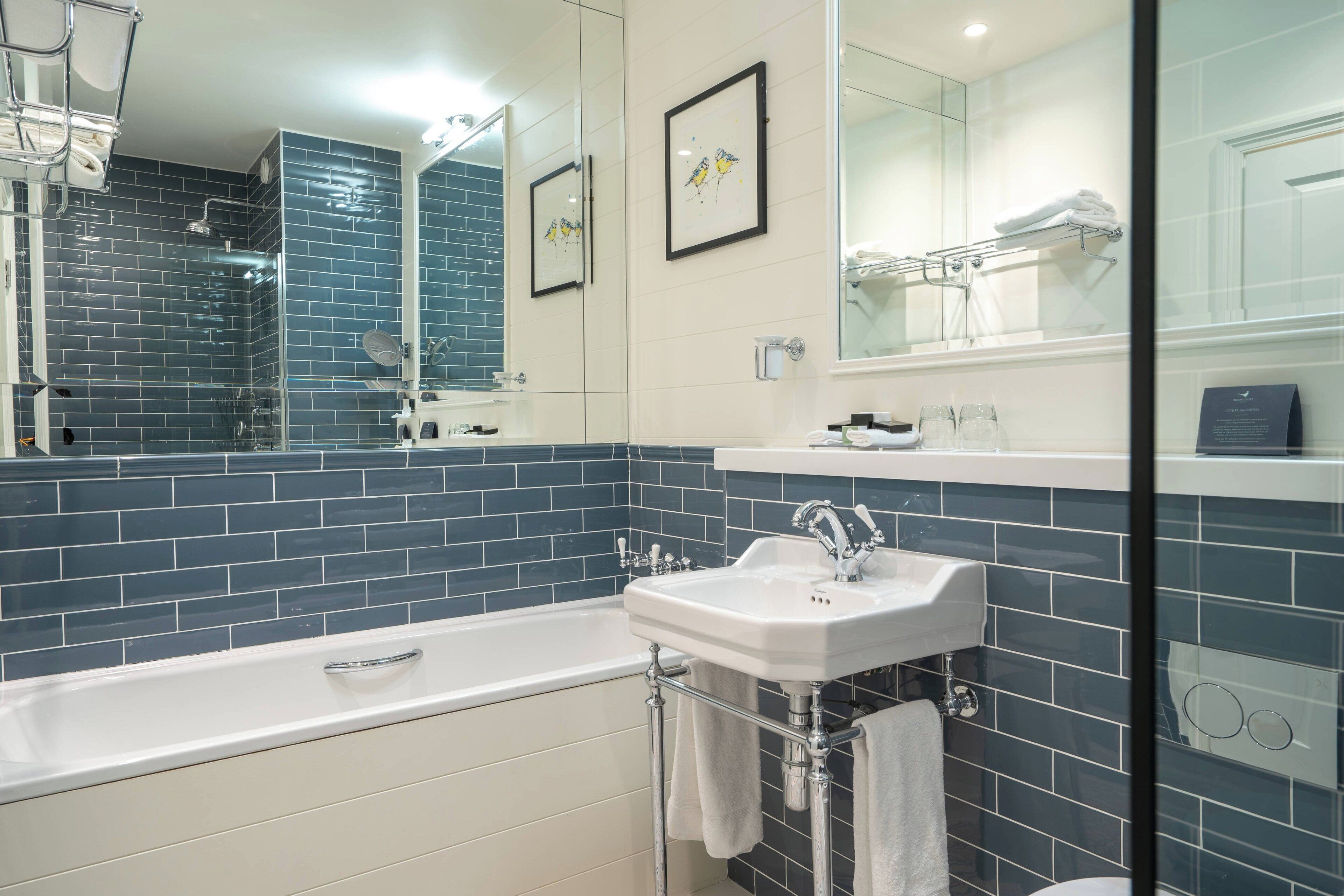 A modern bathroom with a bathtub, a sink, and a large mirror.