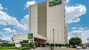 Un hotel moderno y alto, con un letrero llamativo que dice "Quality Inn".